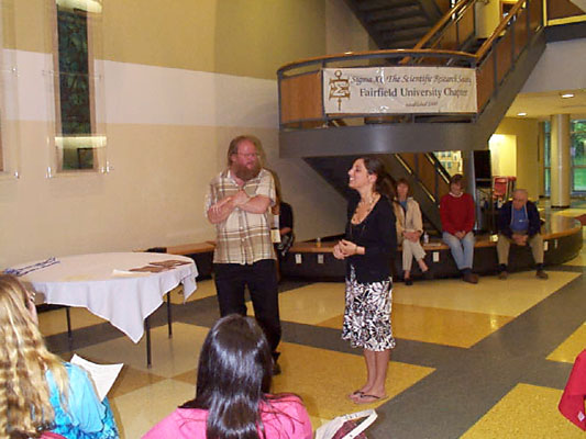 Erika Vieira smiles as Professor Kraig Steffen talks about her research in chemistry